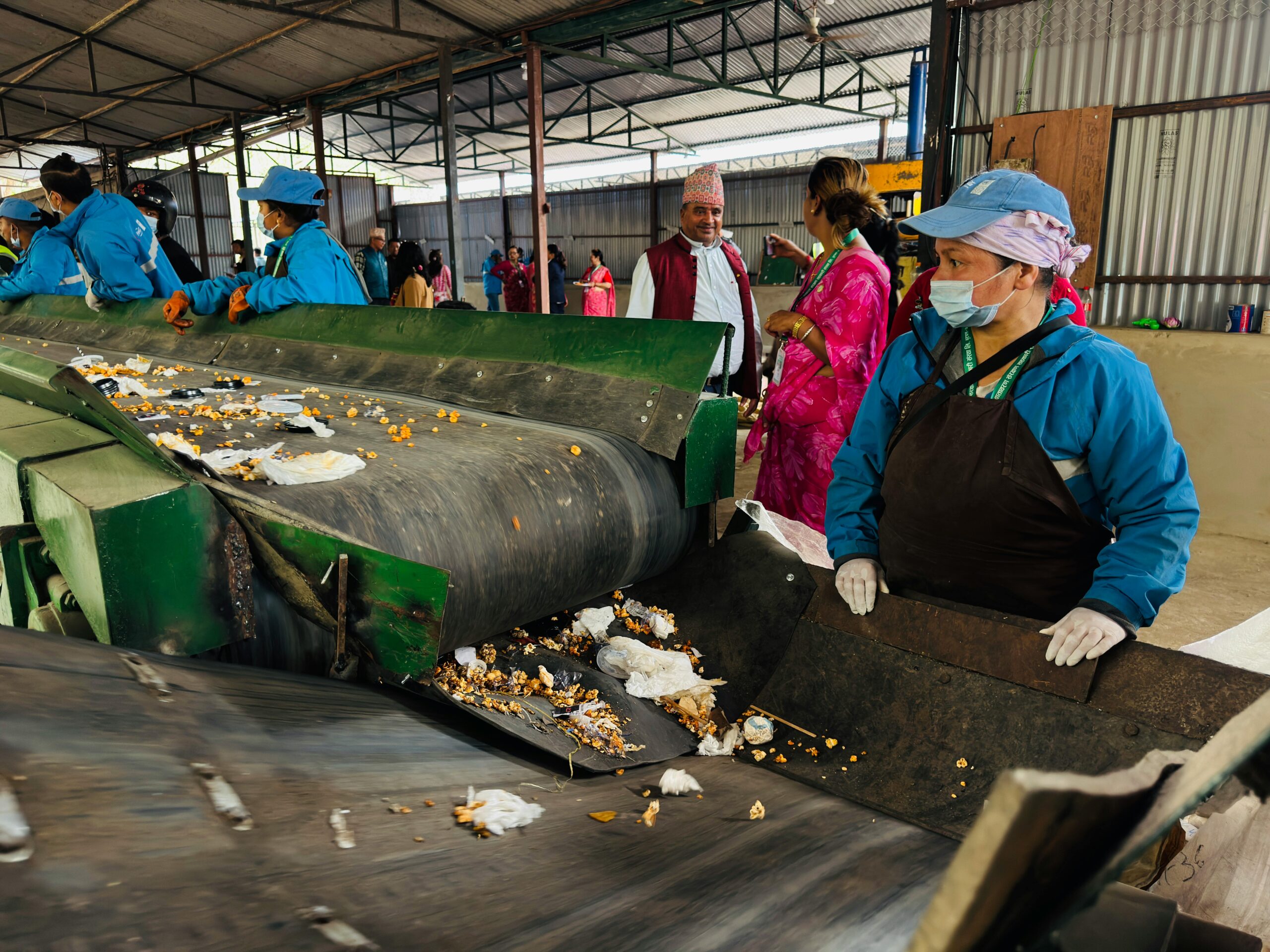 Workers sorting waste in a recycling facility in Butwal, Nepal, showcasing environmental sustainability efforts.